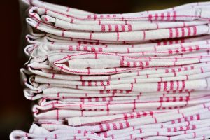 Folded red and white tea towels stacked up neatly